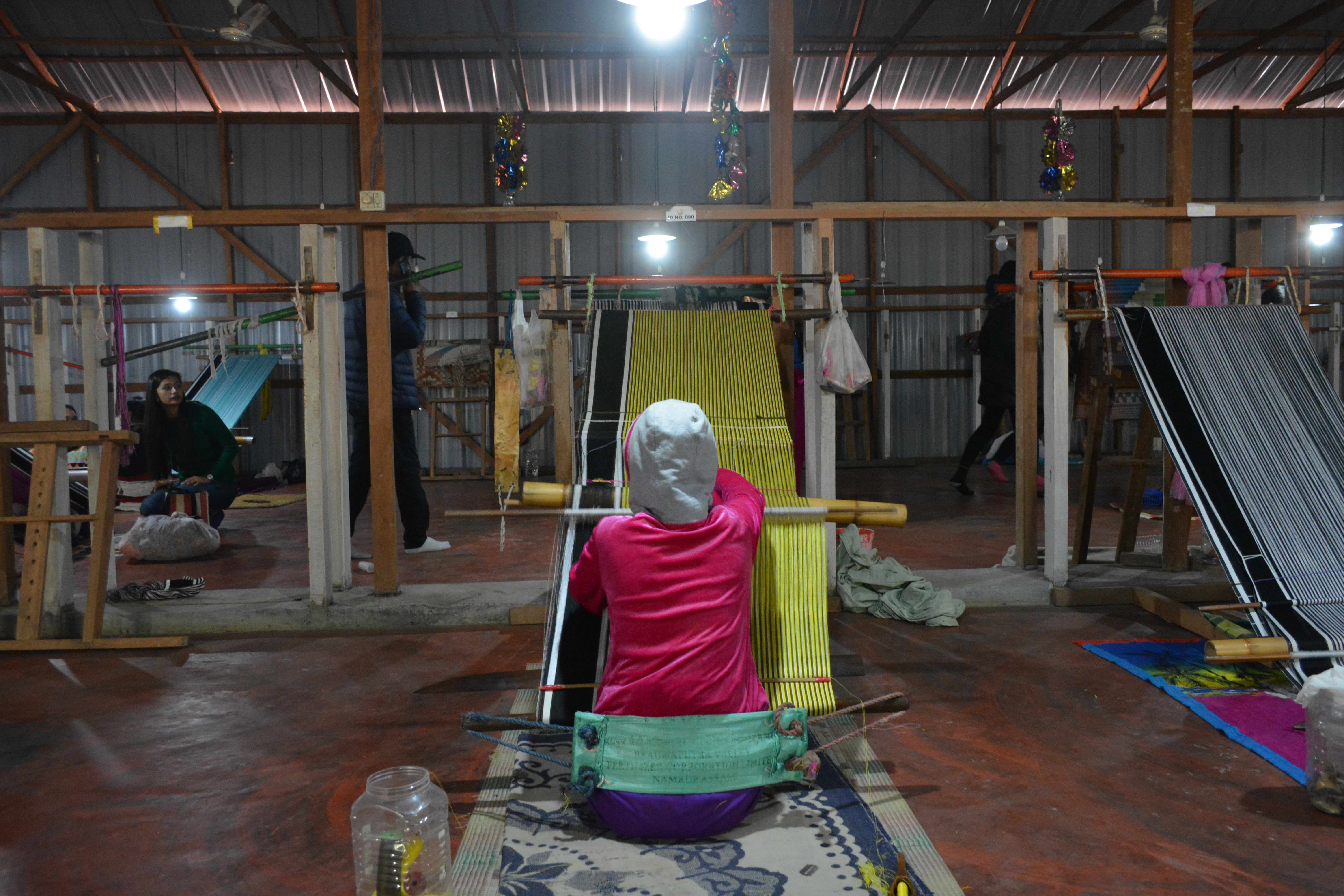 A local artisan hand weaving traditional attire (phanek)