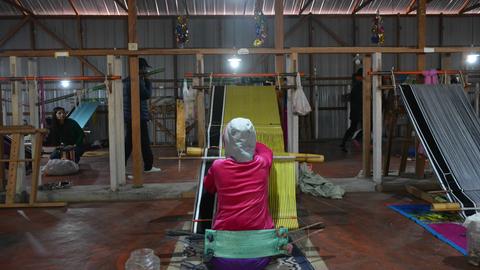 A local artisan hand weaving traditional attire (phanek)